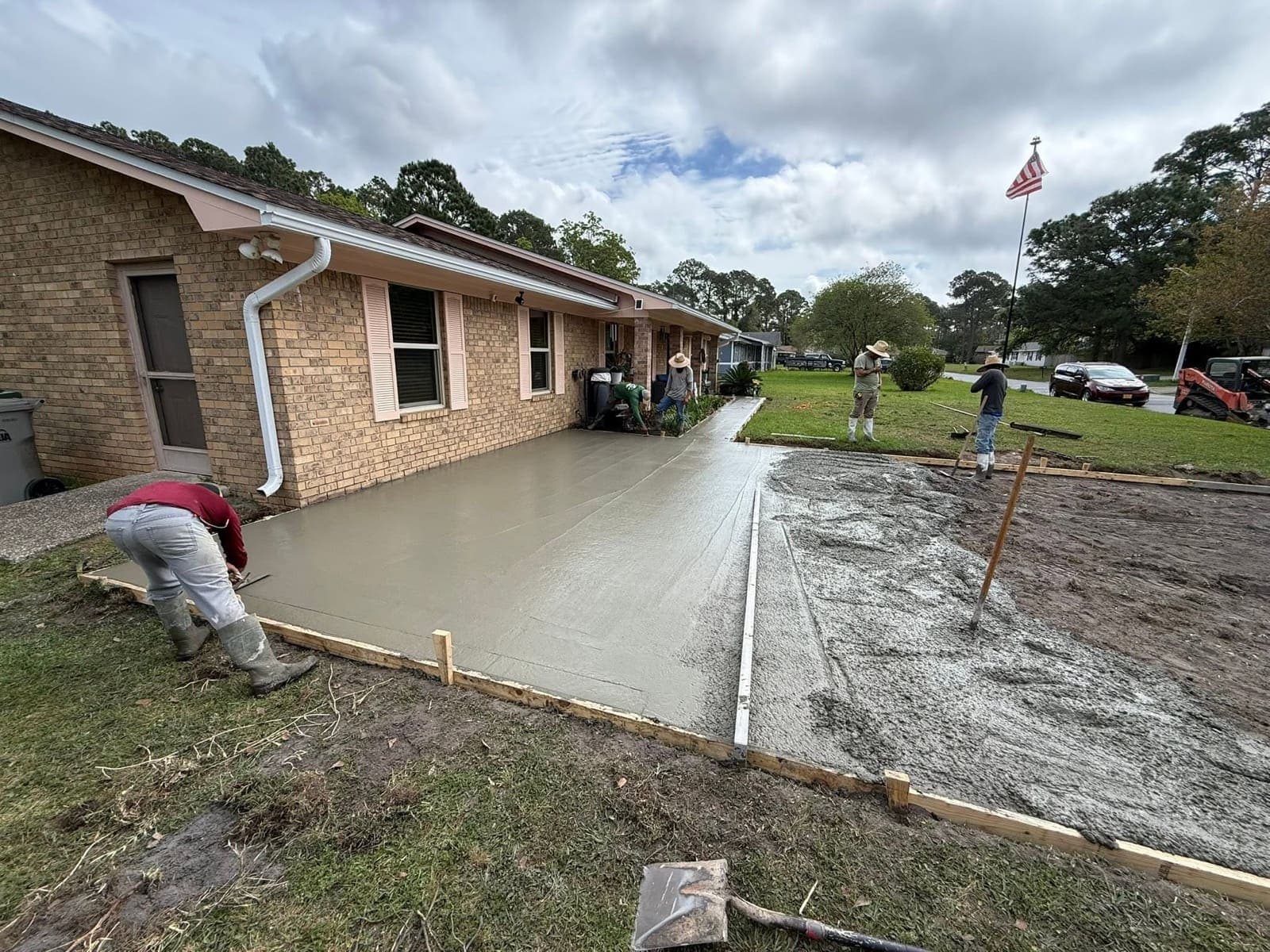 Compact track loader grading a residential lot after removing an old driveway